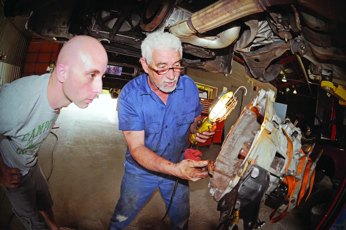 Mecánicos de Tecniussautos revisando un vehículo en el elevador